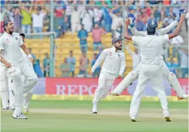 ??  ?? BANGALORE: Indian captain Virat Kohli (C) and teammates celebrate their match victory against Australia on the fourth day of the second Test match between India and Australia at The M. Chinnaswam­y Stadium in Bangalore yesterday. — AFP