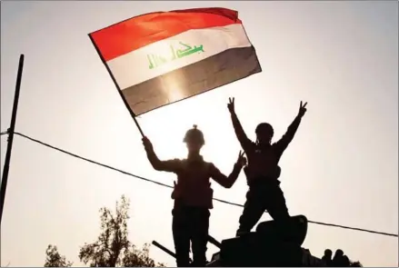  ?? FADEL SENNA/AFP ?? Iraqi federal police wave the national flag as they celebrate in the Old City of Mosul on Sunday after the government’s announceme­nt of the ‘liberation’ of the embattled city from Islamic State.
