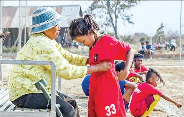  ?? SUPPLIED ?? Kimhong and her mother, Thy, on a football pitch in Battambang province. Thy uses a prosthetic limb after losing a leg to a landmine several years ago.