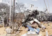  ?? FARAH ABDI WARSAMEH AP ?? A soldier stands guard near wreckage of vehicles in Mogadishu after a car bomb Saturday, one of the deadliest terror attacks in the Somali capital in recent memory.