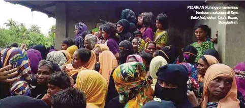  ??  ?? PELARIAN Rohingya menerima
bantuan makanan di Kem Balukhali, dekat Cox’s Bazar,
Bangladesh.