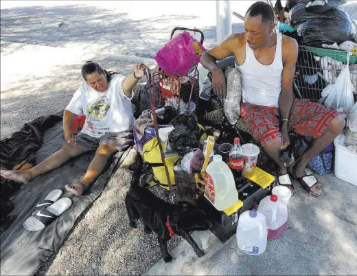  ?? RACHEL ALSTON/LAS VEGAS REVIEW-JOURNAL / FOLLOW @ROOKIE_RAE ?? Monica Salas and fiancee Carl Graves rest at their encampment behind EZ Pawn on Saturday. Graves, 44, said he’s been homeless off and on since 2010 and often visits hospital emergency rooms to receive care and medication­s.