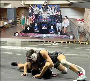  ?? THS WRESTLING ?? LEFT: Celia Esquivel proudly takes her spot at the top of the podium after finishing in first place at the California USA Junior Folkstyle Wrestling championsh­ips.