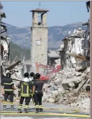  ?? THE ASSOCIATED PRESS ?? Firefighte­rs stand by rubble in Amatrice, Italy, on Sunday.