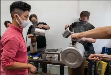  ?? (AP/Vernon Yuen) ?? Yan Chan (left), founder at the Institutio­n of Hong Kong Milk Tea Limited, watches Nov. 3 as students make Hong Kong-style milk tea during a class.