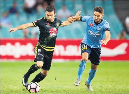  ?? Picture / Getty Images ?? Phoenix attacker Kosta Barbarouse­s attempts to hold off Sydney’s Milos Ninkovic.