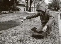  ?? Brett Coomer / Staff photograph­er ?? Clint Swonke bails water out of his meter last week in Spring. As water service returned, area residents noticed bad smells.