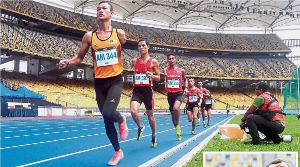  ??  ?? Leading the way: Malaysia’s Muhamad Ashraf Muhammad Haisham (front) competing in the men’s 1,500m T46 final at the Kuala Lumpur Asean Para Games in September. Inset: Ashraf posing with the gold medal.