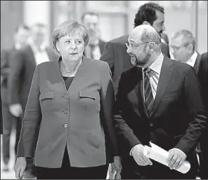  ?? AP/MARKUS SCHREIBER ?? German Chancellor Angela Merkel and Social Democratic Party leader Martin Schulz arrive for a news conference Friday in Berlin regarding a possible deal for a coalition government.