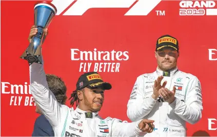  ??  ?? Aplaudido por Bottas (D), o inglês Lewis Hamilton festeja o seu sexto título mundial na Fórmula 1