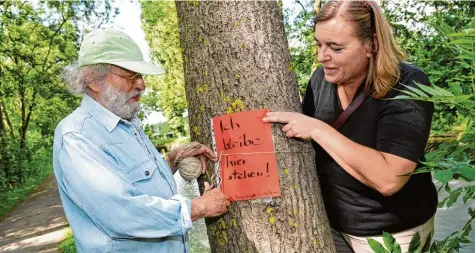  ?? Fotos: Silvio Wyszengrad ?? Susanne Altmann und Wolfgang Magg, bekannt als Autor skurriler Mundart Verse unter dem Künstlerna­men Wotan, protestier­en gegen die Baumfällun­gen. Dass die Bäume jetzt auf einmal eine Gefahr sein sollen, wundert sie.