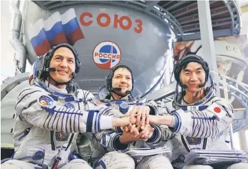  ??  ?? (From left to right) Nasa astronaut Kjell Lindgren, cosmonaut Oleg Kononenko of the Russian Federal Space Agency (Roscosmos) and Kimiya Yui of the Japan Aerospace Exploratio­n Agency (JAXA) pose for a picture as they attend a training examinatio­n at the...