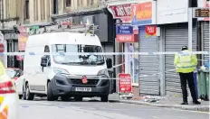  ??  ?? Scene
An officer stands guard in Broomlands Street, Paisley