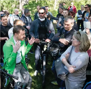  ?? FOTO: SEBASTIAN KAHNERT / DPA ?? Debatte ohne Mundschutz: Ministerpr­äsident Michael Kretschmer (li.) diskutiert mit Bürgern, die im Großen Garten in Dresden gegen Corona-Beschränku­ngen demonstrie­ren.