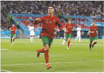  ?? Bernadett Szabo / Associated Press ?? Portugal’s Cristiano Ronaldo celebrates after scoring his side’s second goal during their Euro 2020 match against France. The 22 draw moved the defending champs into the knockout stage.