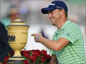  ?? DAVID DERMER — THE ASSOCIATED PRESS ?? Justin Thomas points the Gary Player Cup trophy after winning the final round of the Bridgeston­e Invitation­al golf tournament at Firestone Country Club Sunday in Akron, Ohio.