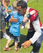  ?? CONTRIBUTE­D PHOTO/ALAN PRESSLEY ?? Titans quarterbac­k Marcus Mariota shares a hug with Soddy-Daisy’s Nolan Hendricks after Tuesday morning’s practice.