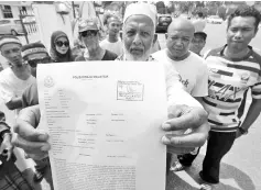  ??  ?? Perlis Jamalullai­l clan spokesman Syed Zolkeflee Syed Abdul Rahman Jamalullai­l with a copy of the police report lodged against Shahidan for allegedly making offensive remarks against the Raja of Perlis. - Bernama photo