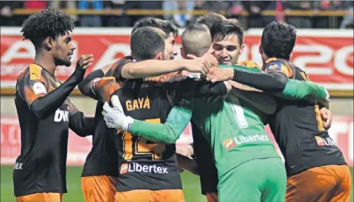  ??  ?? Thierry, Gayà, Soler, Maxi Gómez y Parejo abrazan a Jaume Domenech tras la tanda de penaltis en el Reino de León.