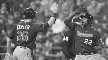  ?? JOHN SLEEZER/TRIBUNE NEWS SERVICE ?? The Minnesota Twins' Miguel Sano (22) celebrates scoring with Max Kepler on a double by Joe Mauer in Kansas City, Mo., on Friday.