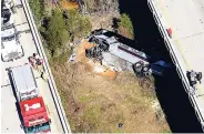  ??  ?? Rescue crews look down on a charter bus after a deadly crash in Loxley, Alabama. The bus, carrying Texas high-school band members home from Disney World, plunged into a ravine before dawn yesterday.