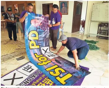  ??  ?? Final preparatio­ns: Volunteers sorting out banners for Isa’s campaign at his operations centre in Kampung Baru Si Rusa, Port Dickson.