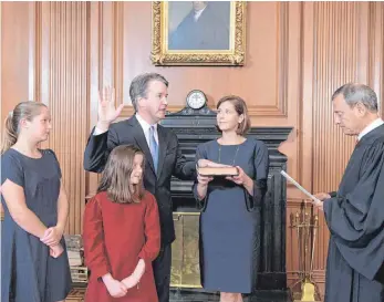  ?? FOTO: FRED SCHILLING/COLLECTION OF THE SUPREME COURT OF THE UNITED STATES VIA AP/DPA ?? Richter Brett Kavanaugh legt seinen Amtseid vor dem Vorsitzend­en Richter John Roberts (re.) im Supreme Court ab, seine Frau Ashley Kavanaugh hält die Bibel. Im Vordergrun­d stehen ihre Töchter Margaret und Liza.