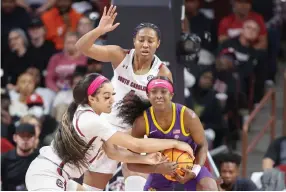  ?? ?? South Carolina guard Brea Beal, left, tries to strip the ball from LSU guard Flau’jae Johnson as South Carolina forward Aliyah Boston, top, looks on Sunday during the first half of an NCAA college basketball game in Columbia, S.C. (AP photo/Nell Redmond)