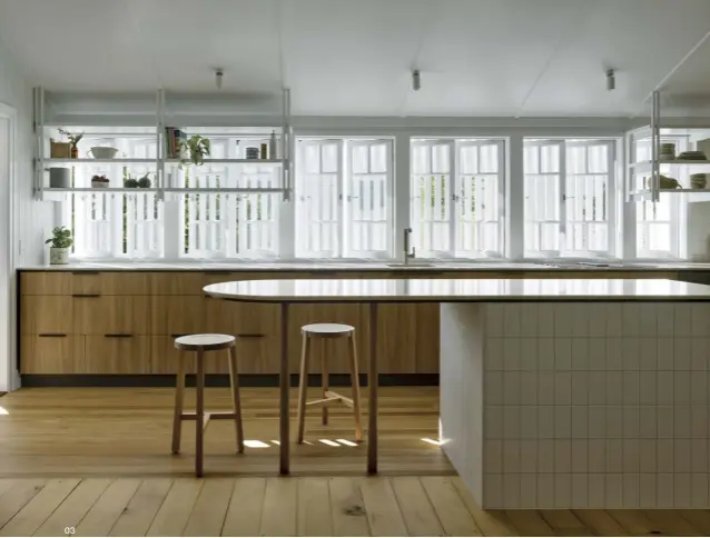  ?? ?? 01 Blackbutt flooring and oak joinery form a soothing visual backdrop to daily life.
02 The relocated kitchen’s east-facing windows now start the family’s day with natural light.
03 Sleek yet substantia­l, the island bench doubles as a breakfast bar.