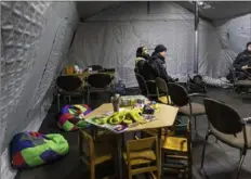  ?? David Guttenfeld­er/The New York Times ?? Ukrainian firefighte­rs wait inside a warming tent that offers relief to residents of a neighborho­od with persistent power outages in Ukraine’s capital, Kyiv, Nov. 29.