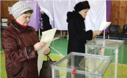  ??  ?? DONETSK: Women look at their ballots at a polling station in Mariupol, in the Donetsk region yesterday. Voters in the east Ukrainian government-held port of Mariupol yesterday cast their ballots in a delayed local elections after an earlier poll was...