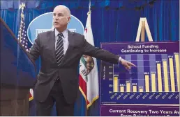  ??  ?? Gov. Jerry Brown gestures to a chart showing the increased spending for school funding while discussing his revised $124 billion state budget plan on Thursday.