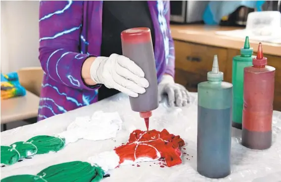  ?? KIM HAIRSTON/THE BALTIMORE SUN PHOTOS ?? Jill Matteson, of Havre de Grace, creates a watermelon design on t-shirts in her kitchen.