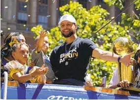  ?? ERIC RISBERG AP ?? Stephen Curry rides with his wife, Ayesha, and their children in the Warriors’ championsh­ip parade in San Francisco on Monday. It was their fourth title in eight years.