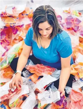  ?? COURTESY OF LAURA KIEF SHAFFER ?? When she’s not working as a flight nurse, Laura Kief Shaffer is supervisin­g volunteers who are making 3D-printed masks, face shield parts and nasal swabs. Here she sorts through some of the printed masks.