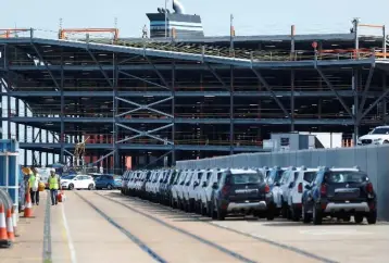  ??  ?? Cars readied for export are parked next to a vehicle storage facility on the dockside at the ABP port in Southampto­n, Britain. The British government will set out a new export strategy on Tuesday aimed at boosting exports to 35 per cent of GDP, as it looks to increase trade ties with the rest of the world after leaving the EU. — Reuters photo