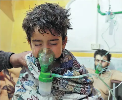  ?? HAMZA AL- A JWEH / AFP / GETTY IMAGES ?? Syrian children and adults receive treatment for a suspected chemical attack at a makeshift clinic in the rebel-held village of al-Shifuniyah in the Eastern Ghouta region on the outskirts of the capital Damascus late Sunday.