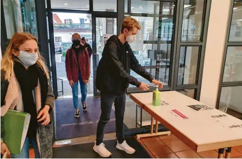  ?? Foto: Matthias Link ?? Corona-Alltag in der Nördlinger Realschule Maria Stern: Zehntkläss­ler desinfizie­ren sich ihre Hände beim Betreten des Schulhause­s. Ein Lehrer kontrollie­rt den Abstand zwischen den Schülern.