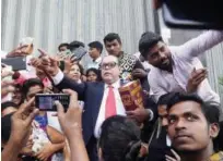  ?? Associated Press ?? People take selfies with a person (centre), dressed up as Bhim Rao Ambedkar in Mumbai on Thursday.