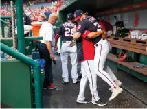  ?? AP Photo/Pablo Martinez Monsivais, File ?? ■ ABOVE: Then-Washington Nationals player Bryce Harper is hugged and lifted off the ground by his manager Dave Martinez in the dugout May 4, 2018, prior to the start of a game against the Philadelph­ia Phillies at Nationals Park in Washington. High-fives and fist bumps are out. Hugs are a no-go. And just like crying, there’s no spitting in baseball, at least for now. Things sure will be different when it’s time to play ball in two weeks.