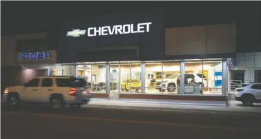  ?? AP FILE PHOTO/DAVID ZALUBOWSKI ?? A a vehicle passes a Chevrolet dealership in Fort Lupton, Colo.