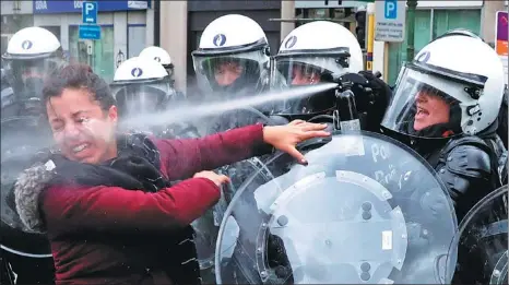  ?? YVES HERMAN / REUTERS ?? A woman is sprayed with an irritant by riot police during a protest against higher fuel prices in Brussels, Belgium, on Saturday. More than 400 people were reportedly detained during the day.