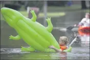  ?? STEVE GONZALES — HOUSTON CHRONICLE ?? Sawyer Chambers, 7, falls off an inflatable as his brother Josey, 11, rides a kayak Tuesday on Wandering Trail after Clear Creek overflowed in Friendswoo­d, Texas.