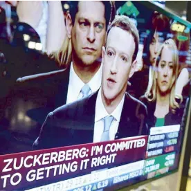  ?? AP ?? Facebook CEO Mark Zuckerberg appears on a television screen on the floor of the New York Stock Exchange as he testifies at the Senate in Washington in a photo taken last month.