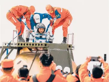  ?? GETTY-AFP ?? Back on Earth: China’s Ye Guangfu, one of three astronauts on the Shenzhou 13 capsule, is helped out of the craft Saturday. The trio, who stayed six months aboard their country’s newest orbital space station, landed in the Gobi desert. During the mission, Wang Yaping carried out the first spacewalk by a Chinese woman. Zhai Zhigang rounded out the crew.