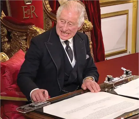  ?? ?? By order: King Charles III gestures for a pen tray and ink pot to be moved so he has more room to write. Above: He grimaces as he asks again for the pens’ removal