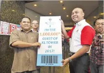  ??  ?? KL Tower chief executive officer Meor Shahril Anuar Ahmad Rathuan presenting the prizes to Ahamat Omar (left). - Bernama photo