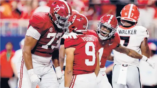  ?? KEVIN C. COX/GETTY ?? Alabama’s Bryce Young celebrates a touchdown with Evan Neal (73) in the SEC Championsh­ip on Saturday.