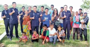  ??  ?? PENDUDUK kampung bersama Douglas dan pegawainya selepas lawatan itu.