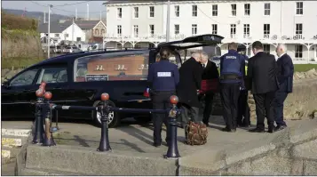  ??  ?? Staff from Thomas Murphy & Sons Undertaker­s and members of the gardaí remove the body from the north end of the beach in front of Martello Terrace on Monday morning.